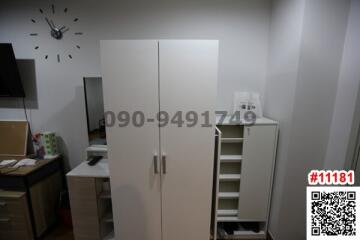 Compact bedroom with modern furniture including wardrobe and shelving unit