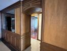 Elegant corridor with wood paneling and archway leading to additional rooms