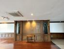 Spacious interior of a building with wooden floors and a classic wooden panel on the wall