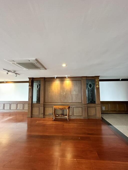 Spacious interior of a building with wooden floors and a classic wooden panel on the wall