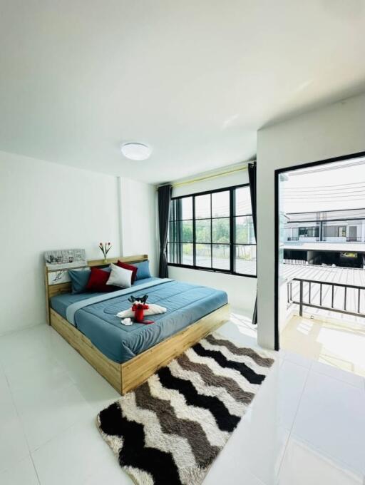 Modern bedroom with large windows and balcony access