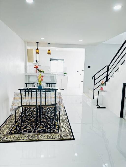 Modern dining area with staircase and white interiors