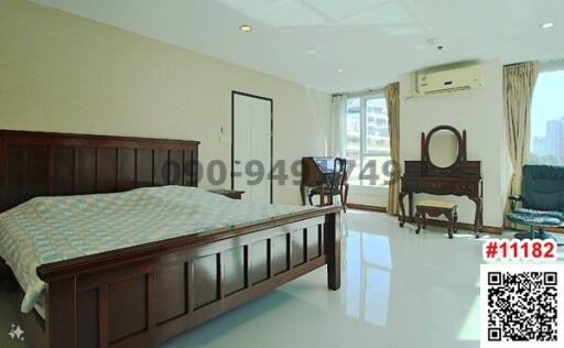 Spacious bedroom with natural light and classic furniture