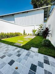 Modern home exterior with landscaped garden and patterned paving