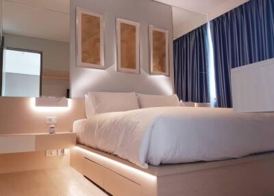 Modern bedroom interior with neatly arranged pillows and artwork