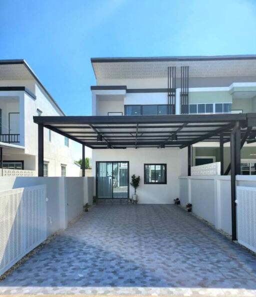 Spacious driveway leading to a modern two-story home with covered parking area