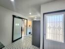 Elegant entrance hall with black and white tiled floor and modern glass door