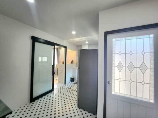Elegant entrance hall with black and white tiled floor and modern glass door