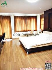 Spacious bedroom with large bed and hardwood floors