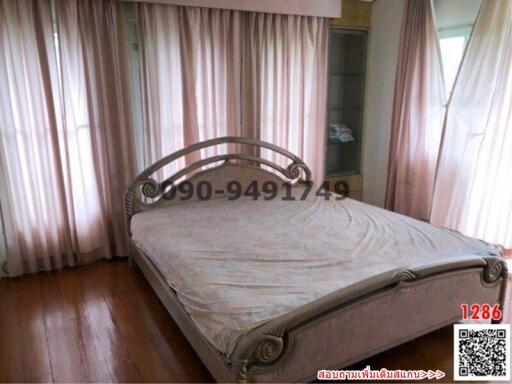 Spacious bedroom with large bed and window drapes