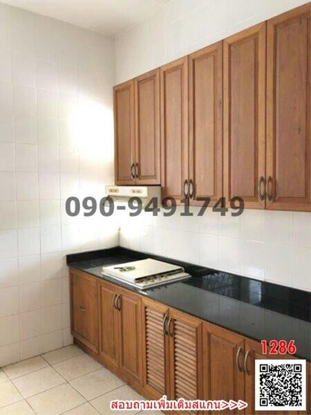 Compact kitchen with wooden cabinets and black countertop