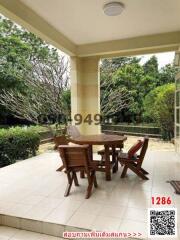 Spacious patio with a wooden table and chairs and a view of the garden