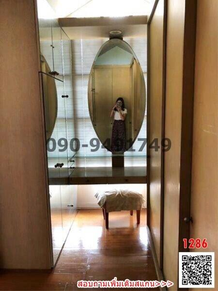 Bedroom with wooden floor and built-in wardrobe mirror reflecting image