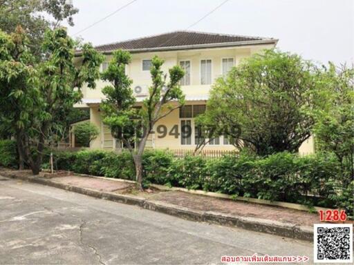 Two-story suburban house with a front garden and trees