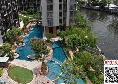 Aerial view of a residential complex with swimming pool and riverfront access