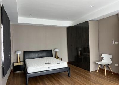 Spacious bedroom with modern furnishings and hardwood floor