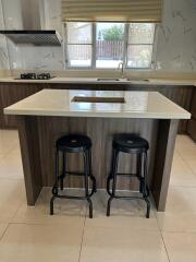 Modern kitchen with breakfast bar and two stools