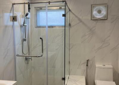 Modern bathroom with marble tiles and glass shower enclosure