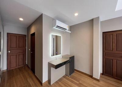 Modern building entrance with wooden floors, air conditioning unit, and elegant doors