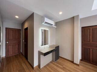 Modern building entrance with wooden floors, air conditioning unit, and elegant doors