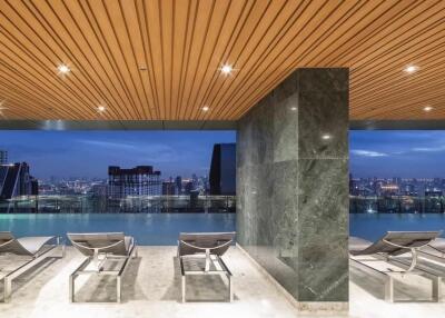 Luxurious high-rise building rooftop pool at dusk with city skyline views