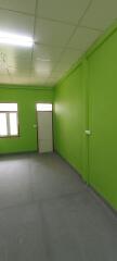 Empty interior room with green walls and fluorescent lighting