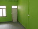 Empty interior room with green walls and fluorescent lighting