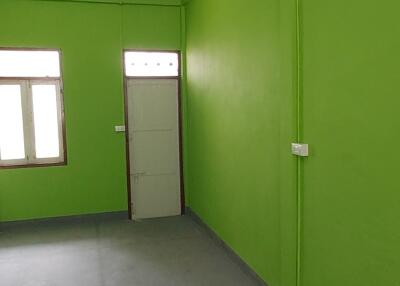 Empty interior room with green walls and fluorescent lighting