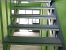 Green painted staircase with metal handrails and steps