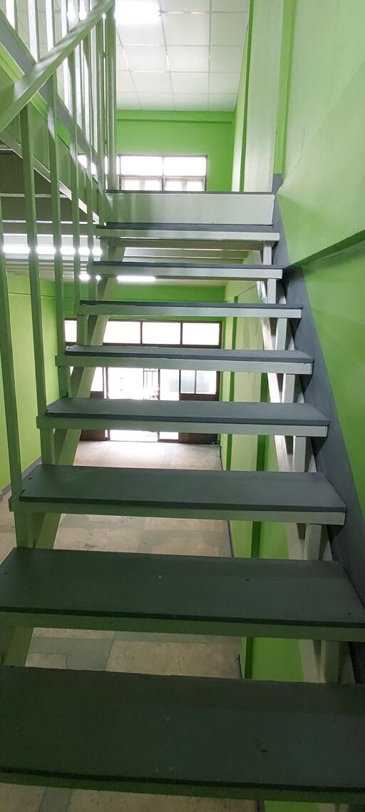 Green painted staircase with metal handrails and steps
