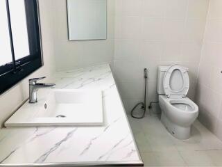 Modern bathroom with white tiles and marbled sink countertop