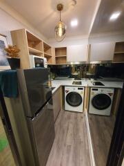 Modern kitchen with stainless steel appliances and laundry area