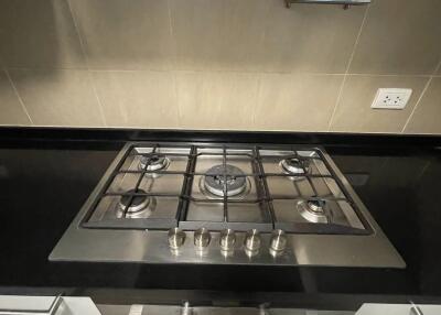 Modern kitchen with stainless steel gas stove and black countertop