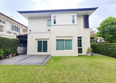 Modern two-story house with green lawn and driveway