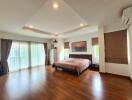 Spacious bedroom with king-sized bed, wooden floors, and ample natural light