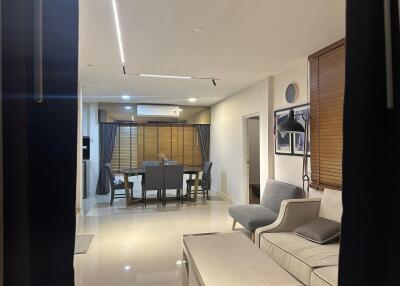 Modern and spacious living room with dining area in the background