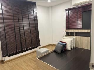 Contemporary bedroom interior with wooden floors and a mounted television