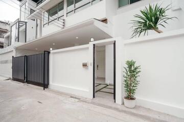 Contemporary home exterior with white walls and a sliding gate