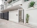 Contemporary home exterior with white walls and a sliding gate