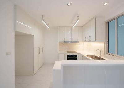 Modern white kitchen with clean design and ample lighting