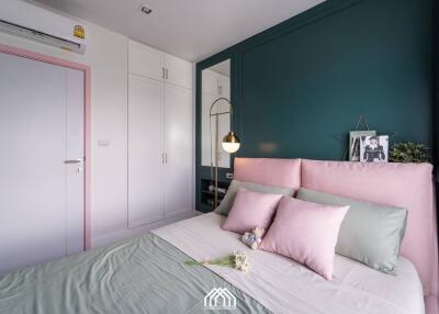 Cozy bedroom with modern decor, mint and pink accents, and built-in storage