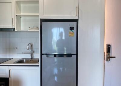 Modern kitchen with stainless steel refrigerator and white cabinetry