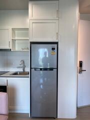 Modern kitchen with stainless steel refrigerator and white cabinetry