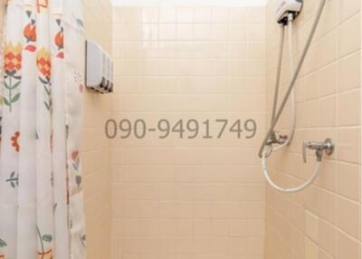 Compact bathroom with shower and printed shower curtain