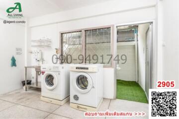 Compact laundry room with white walls, washing machines, and access to outdoor area