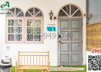 Entrance of a house with a wooden door and arched windows