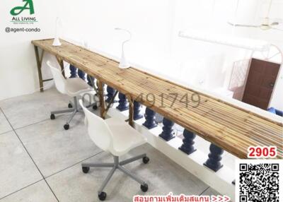 Spacious office area with a long communal wooden desk and modern chairs