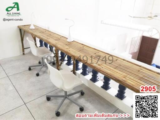 Spacious office area with a long communal wooden desk and modern chairs