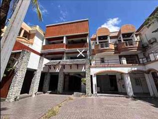 Multi-story residential building with balconies and parking space