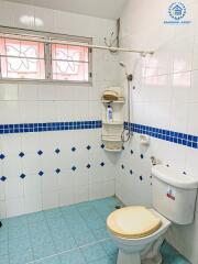 Bright tiled bathroom with shower and toilet